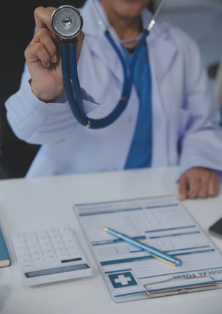 Close-up of female doctor using stethoscope , focus on stethoscopeの写真素材