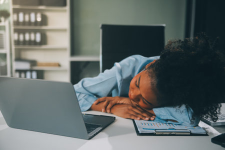 Sad tired young asian lady thinking, sleep at laptop, suffering from overwork, stress in room interior. Deadline, problems in study, work, business, freelance at home new normal with techの写真素材