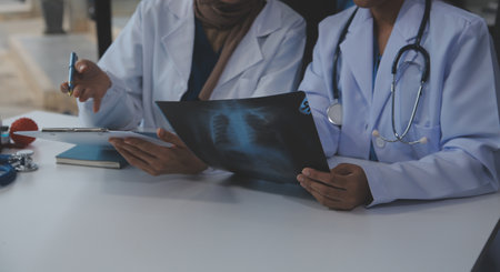 Doctor discussing diagnosis during the meeting. Group of doctor discussing work matter in the office at work. The medical team discusses treatment options with the patient.の写真素材