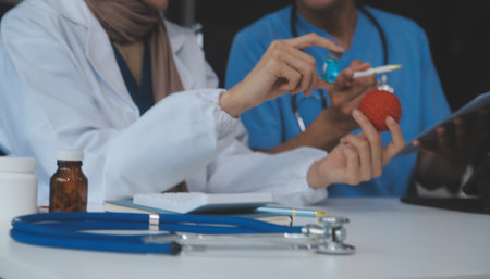 Doctor discussing diagnosis during the meeting. Group of doctor discussing work matter in the office at work. The medical team discusses treatment options with the patient.の写真素材
