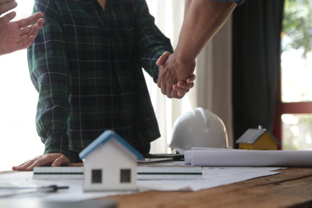 Engineer and contractor join hands after signing contract,They are having a modern building project...