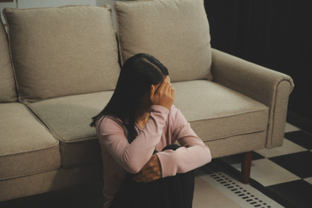 Depressed woman sitting alone on the bed with hands on head feel stress, sad and worried in the dark...