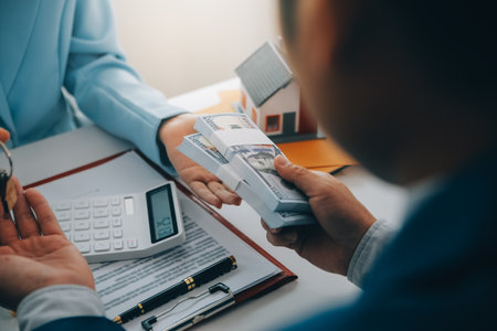 Real estate agent talked about the terms of the home purchase agreement and asked the customer to sign the documents to make the contract legally, Home sales and home insurance concept.の写真素材