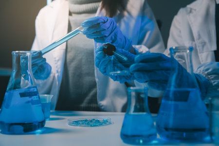 chemist,scientist hand dropping chemical liquid into test tube, science research and development conceptの写真素材