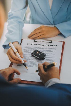 Insurance officers hand over the car keys after the tenant. have signed an auto insurance document or a lease or agreement document Buying or selling a new or used car with a carの写真素材