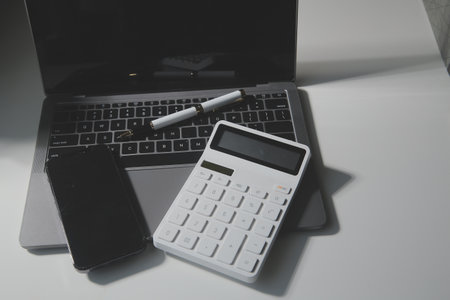Office leather desk table with calculator and pen. Top view with copy spaceの写真素材