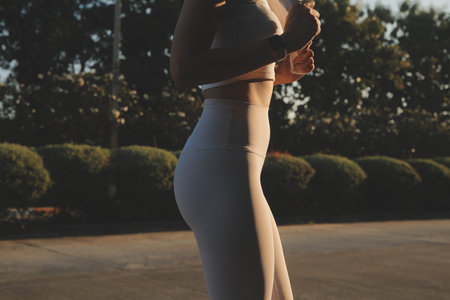 Young fitness woman runner stretching legs before run on cityの写真素材