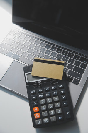 Calculator on a dark background, plastic cards and banknotesの写真素材