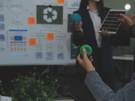 Business people having consultation about wind energy at company office. Business team discussing about windmill and alternative green energy. Executive meeting at modern officeの写真素材