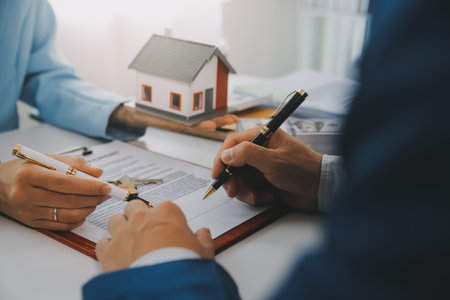 Real estate agent talked about the terms of the home purchase agreement and asked the customer to sign the documents to make the contract legally, Home sales and home insurance concept.の写真素材