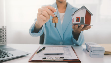 Real estate agent talked about the terms of the home purchase agreement and asked the customer to sign the documents to make the contract legally, Home sales and home insurance concept.の写真素材