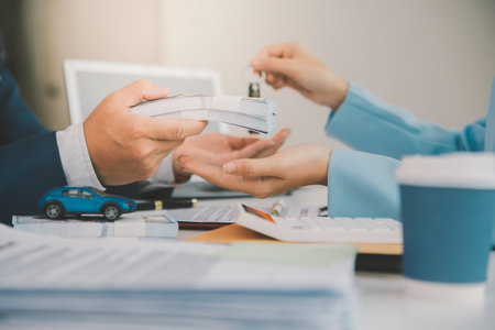 Insurance officers hand over the car keys after the tenant. have signed an auto insurance document or a lease or agreement document Buying or selling a new or used car with a carの写真素材