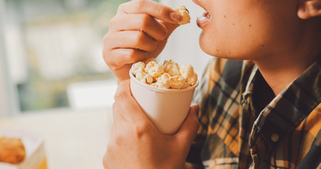 A woman holding a bowl of popcornの写真素材