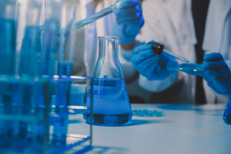chemist,scientist hand dropping chemical liquid into test tube, science research and development conceptの写真素材