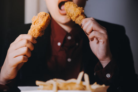 close up focus woman hand hold fried chicken for eat,girl with fast food conceptの写真素材