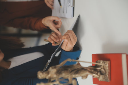 Lawyer, legal advisor, businessman brainstorming information on agreement details Business contracts in legal processing books for accuracy in contract documents. joint financial investment.の写真素材