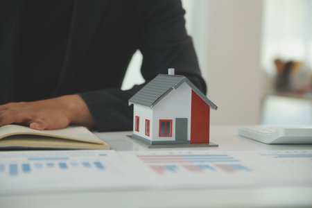 Businessmen holding pens, signing home titles with insurance, care about real estate services and the idea of real estate agents offering interest in installments to their customers.の写真素材