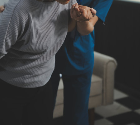 Female caregiver doing regular check-up of senior woman in her home.の写真素材