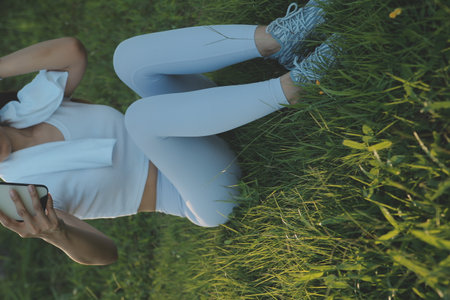 Young fitness woman runner stretching legs before run on cityの写真素材