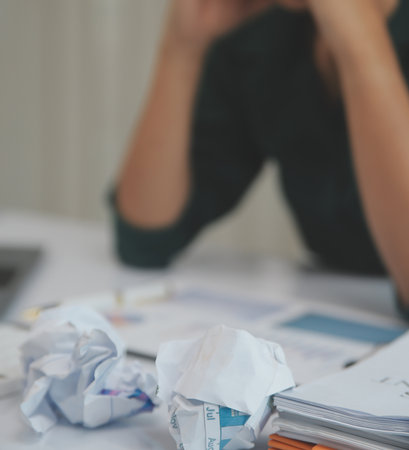 Asian women sitting in a home office With stress and eye strain.Tired businesswoman holding...