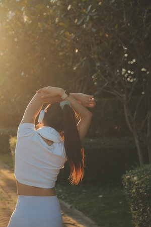 Young fitness woman runner stretching legs before run on city
