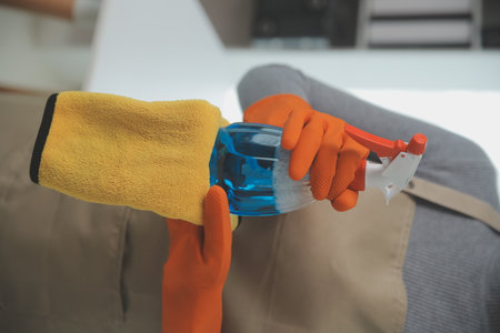Woman cleaning table using rag and diffuser at home.