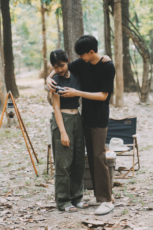 Asian couple sweet in tent inside on they camping trip, traveller relax and sleep togather in out door and camping tripの写真素材