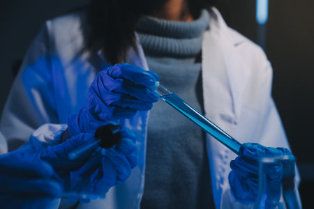 chemist,scientist hand dropping chemical liquid into test tube, science research and development conceptの写真素材