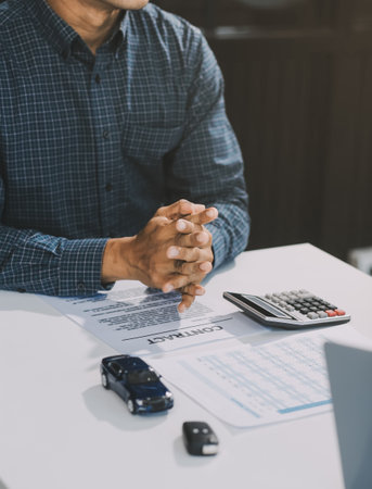 Car sales representative gives keys to new car owner, concept for car rental Focus on the key. Pick up the key. Close-up of the key transfer from the new machine to the buyer.の写真素材