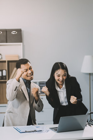 Two happy friendly diverse professionals, teacher and student giving high five standing in office celebrating success, good cooperation result, partnership teamwork and team motivation in office work.の写真素材