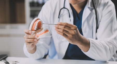 A dentist is using specialized dental equipment to inspect dentures to study the anatomy of the...