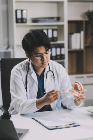 A dentist is using specialized dental equipment to inspect dentures to study the anatomy of the...