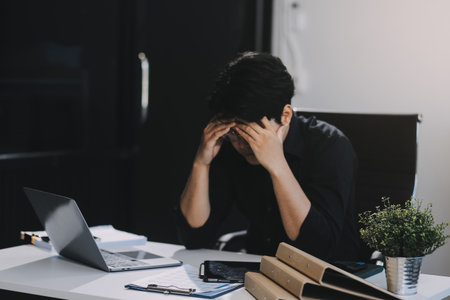 Frustrated Asian young businessman worker working on table in office. Busy employee worker people...