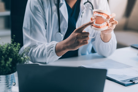 A dentist is using specialized dental equipment to inspect dentures to study the anatomy of the...