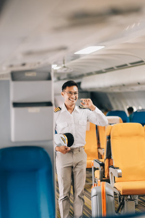 Portrait of a trained airplane captain in uniform preparing to fly in a simulator cockpit.の写真素材