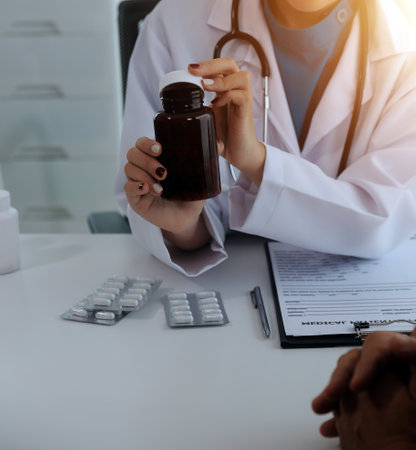 Doctor prescribing medicine giving pills to senior grandmother patient at hospital.の写真素材