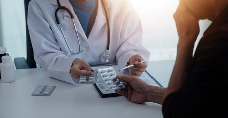 Doctor prescribing medicine giving pills to senior grandmother patient at hospital.の写真素材