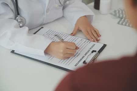Doctor prescribing medicine giving pills to senior grandmother patient at hospital.の写真素材