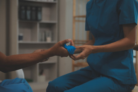 Professional physical therapist examines and cares for a young man in a physical therapy center, treating muscles and injuries of a man in a hospital.の写真素材