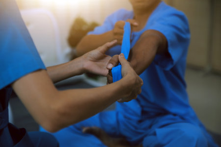 Professional physical therapist examines and cares for a young man in a physical therapy center, treating muscles and injuries of a man in a hospital.の写真素材