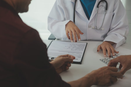 Doctor prescribing medicine giving pills to senior grandmother patient at hospital.の写真素材