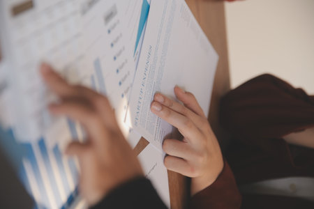 Group of confident business people point to graphs and charts to analyze market data, balance sheet, account, net profit to plan new sales strategies to increase production capacity.の写真素材