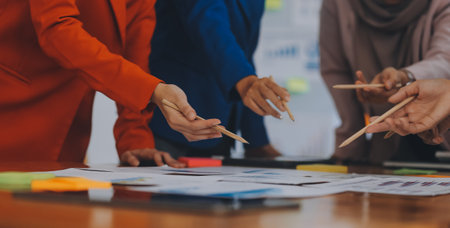 Business professionals. Group of young confident business people analyzing data using computer while spending time in the officeの写真素材
