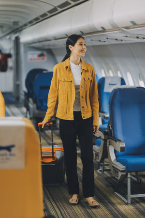 Young Female Tourist with Luggage Walking Through Airplane Cabin Ready for Travel Adventure