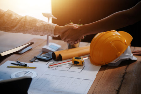Architect men making handshake in construction site. Employee or worker shake hands to employer man for greeting, dealing, teamwork, collaboration some project or business. They are good teamの写真素材