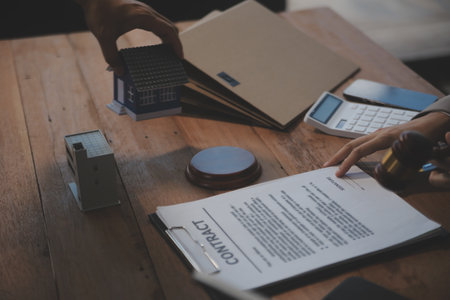 Real Estate Law, Home Insurance, property Tax, Auction and Bidding concepts. small toy house model with gavel justice hammer on desk in courthouse.の写真素材