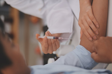 Doctor uses hypodermic needle and syringe to put a dose of medicine as treatment.の写真素材