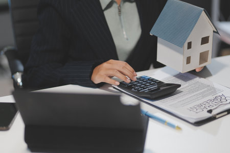 Real estate agents explain models of housing estates in projects to elaborate to clients, explaining and presenting information about homes and purchasing loans. Real estate trading concept.の写真素材