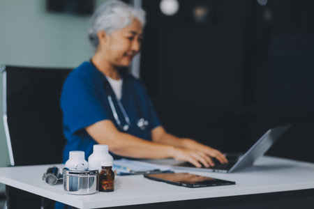Thoughtful Hispanic female doctor sitting at her desk in a bright medical office, looking at a...