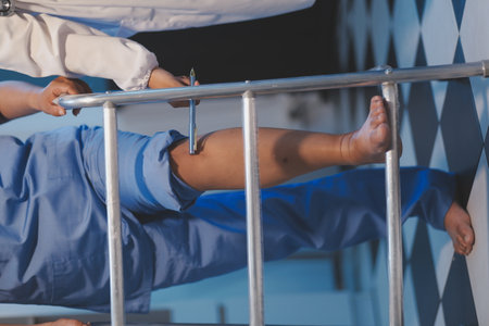 Asian young professional successful friendly female nurse in blue hospital uniform helping supporting physical therapy senior old pensioner unhealthy injury woman patient walking via four legs walker.の写真素材